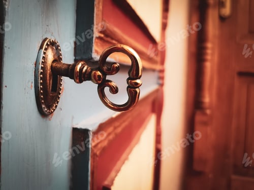 Preview: Close-up shot of a vintage steel key in a lock on a vintage door.