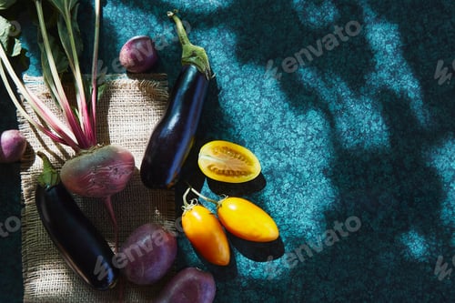 Preview: Bright fresh vegetables - yellow tomatoes, eggplant, beetroot under trendy hard shadows
