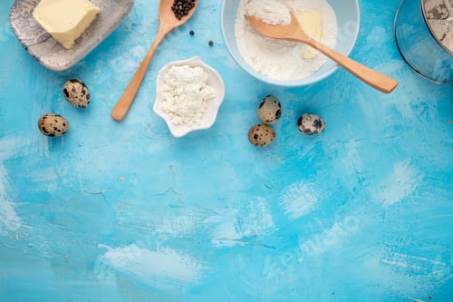 Preview: close-up view of foods as cottage cheese, egg, flour, butter with black pepper on blue background