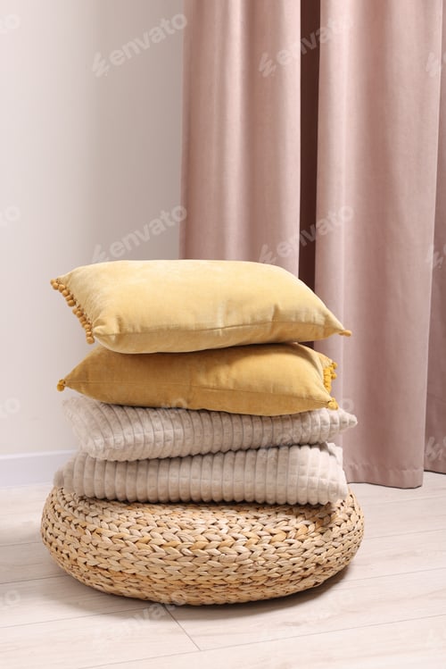 Preview: Soft pillows on wicker pouf in room