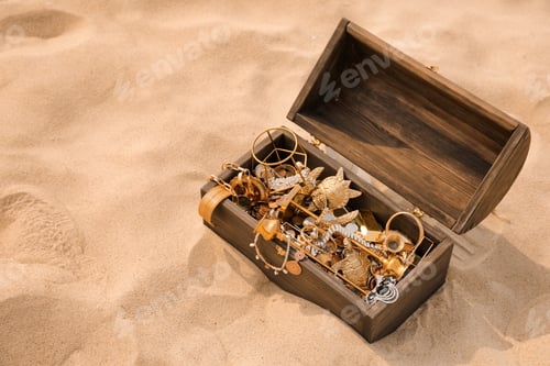 Preview: Open wooden chest with treasures on sand, space for text