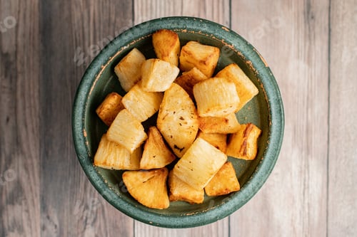 Preview: Bowl of a traditional street food fried yuca in Honduras on a wooden table