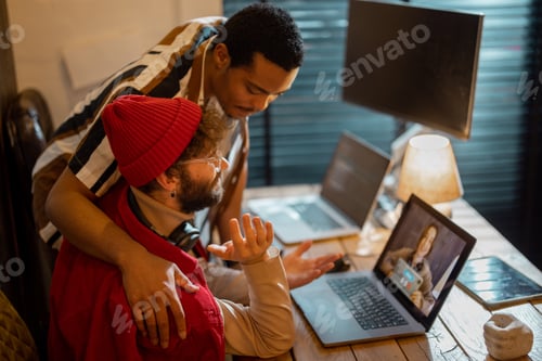 Preview: Stylish gay couple having video call with female colleague