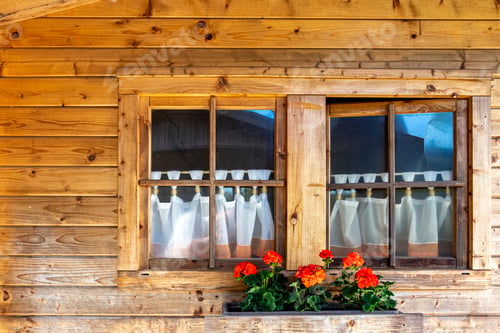 Preview: Windows and flowers on a wooden house