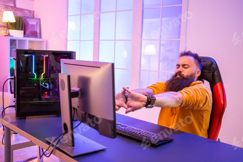 Preview: Professional gamer with long beard in front of powerful gaming rig