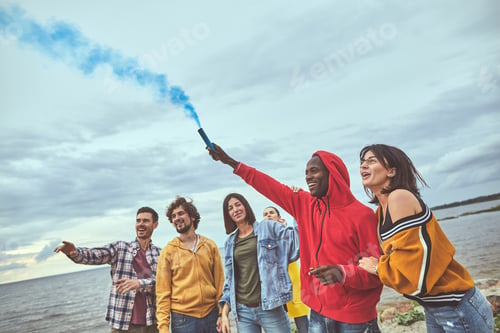 Preview: Joyful Adventure. Portrait Of Friends Gathering To Celebrate Holiday And Setting Smoke Blue Candle