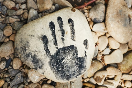 Preview: Hand print on stone. Human imprint. Close up of handmark. Sign left by human. Black print. Identity