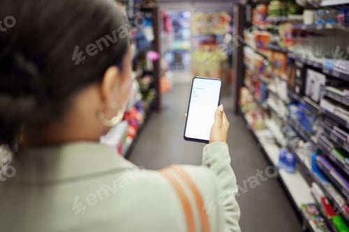 Preview: Woman shopping with phone screen at shop, reading grocery list on smartphone and looking for food i