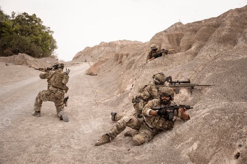 Preview: Soldiers aiming with their rifles
ready to fire during military operation in the desert