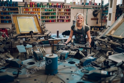 Preview: Graphic worker working with carousel printing machine at print shop.