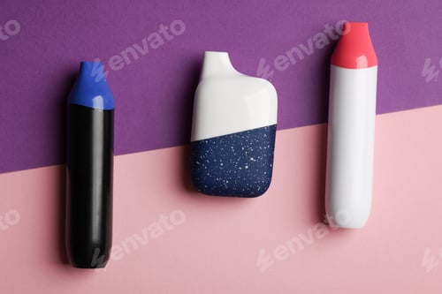 Preview: disposable electronic cigarette or vape on purple background. top view copy space.