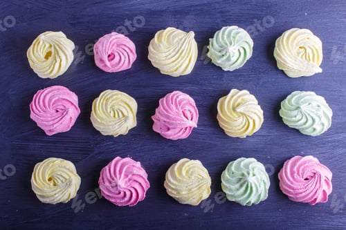 Preview: set of colored meringues on black wooden background. geometric pattern.