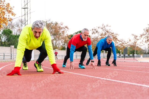 Preview: Ready to Race: Senior Runners Poised at the Start on Athletic Track