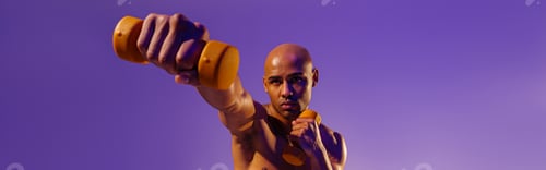 Preview: Muscular man doing exercise with weight dumbbells on studio background. Strength and motivation