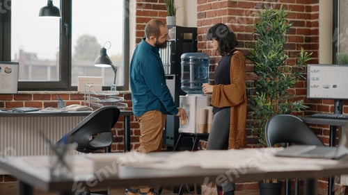 Preview: Colleagues meeting on break while having refreshment from water cooler