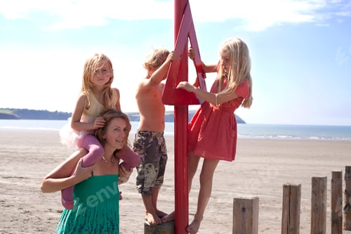 Preview: Mother with three children on beach, Wales, UK