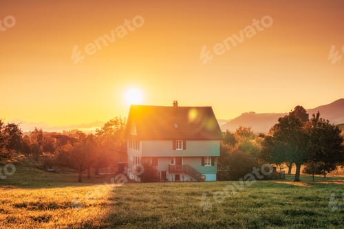 Preview: Sunrise over house on hill among the garden in countryside