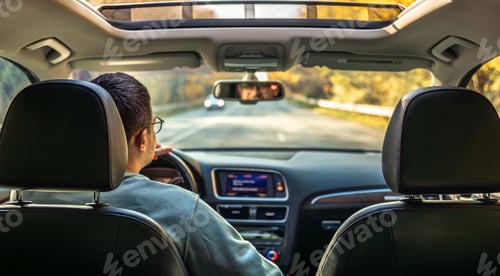 Preview: Driving the modern car on asphalt road. A young man drives a car.