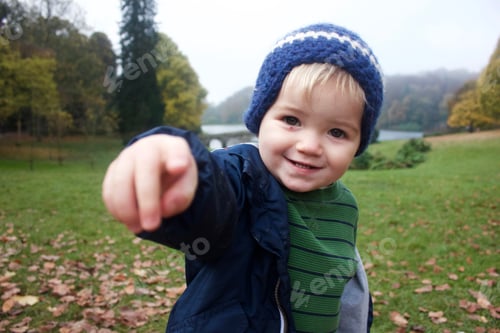 Preview: Cute happy little boy pointing at camera in beautiful park in fall clothing