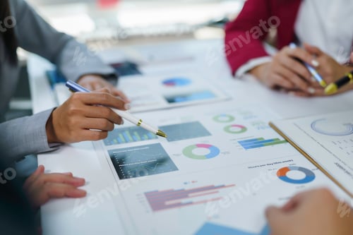 Preview: Business people analyzing financial data charts in meeting