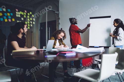 Preview: Creative colleagues having meeting and working with flip chart