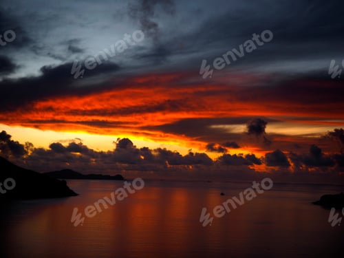 Preview: Breathtaking view of a fiery sunset reflecting off the glassy water surface below
