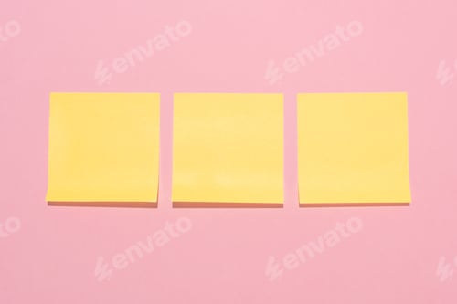 Preview: top view of blank yellow stick it notes placed in row on pink