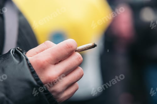 Preview: Woman's hand holding a cigarette in the street