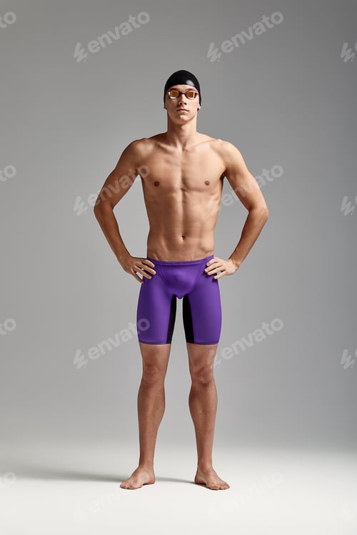 Preview: A male swimmer stands with crossed arms, on a gray background, challenging, spears space