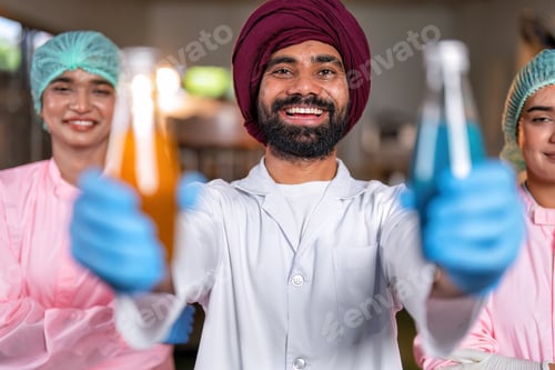 Preview: Beverage worker in drink factory stand smiling portrait with drink bottle and production line