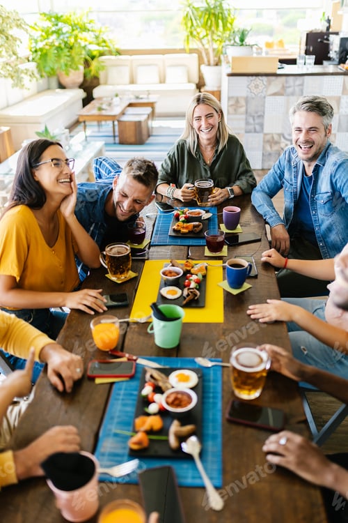 Preview: Group of young people having fun drinking on a rooftop terrace of a restaurant