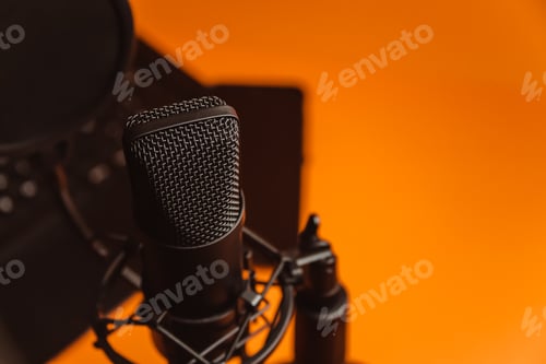 Preview: Close up mock up of a streaming microphone with a laptop over an orange background