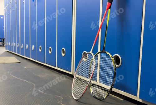 Preview: Shuttlecock on badminton racquet on floor.