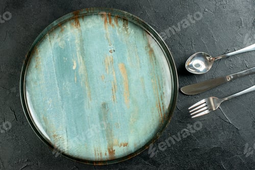 Preview: top view round plate fork knife and spoon on dark ground