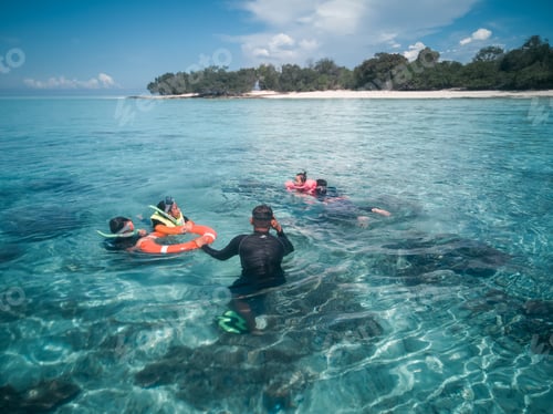 Preview: children swimming using float, tourists at the crystal clear sea