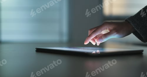 Preview: Touching on tablet computer on table at night