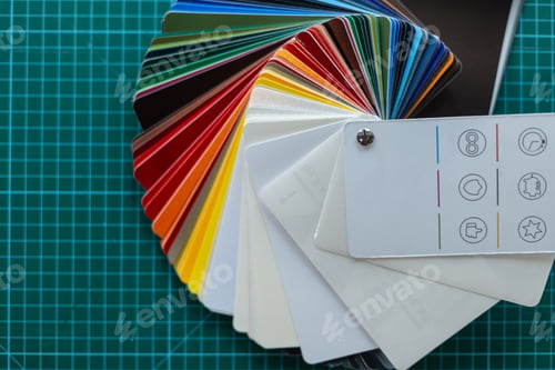 Preview: Set of car protective film color samples on green work table with grid. Creative process