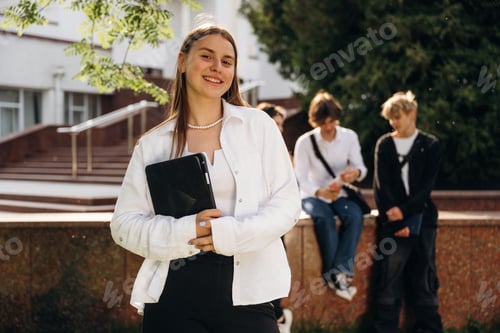 Preview: Girl is standing in front of her friends. Group of students are near university together