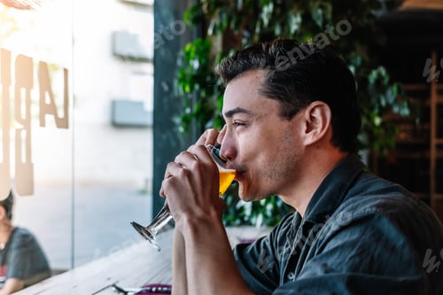 Preview: Man speaking on mobile phone and drinking beer