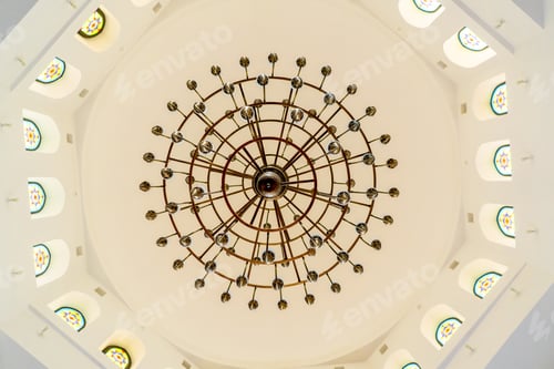 Preview: A beautiful luxury gold chandelier hangs in the hall of a Muslim mosque on a white ceiling