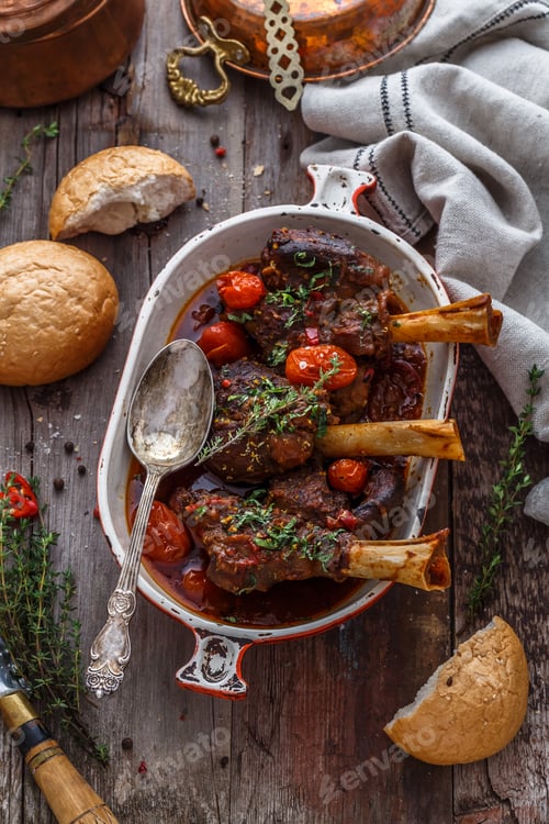 Preview: Lamb shanks in rich tomato sauce with bread and herbs, top view