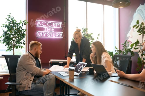 Preview: Group of architects analyzing floor plan in workplace