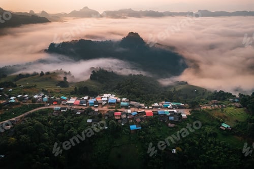 Preview: Aerial view of Morning fog and mountains with a rural village and sunrise from above