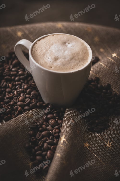 Preview: Vertical shot of a cup of coffee and beans on a piece of fabric