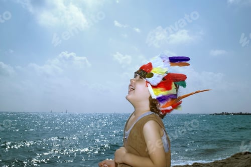 Preview: Toddler in Indian headdress on beach