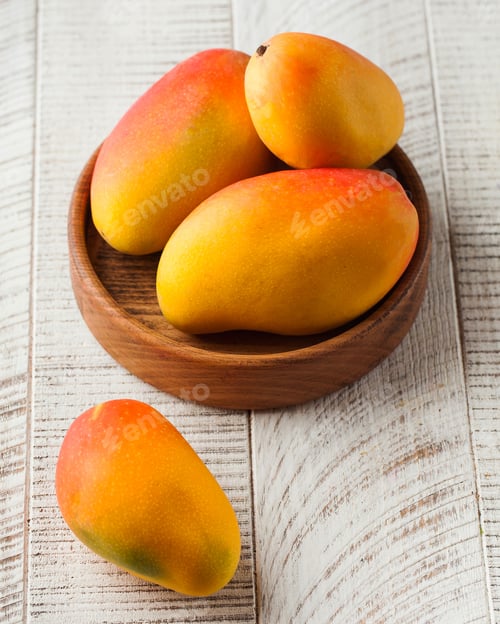 Preview: Ripe mango fruits on a white wooden background. Tropical fruits.