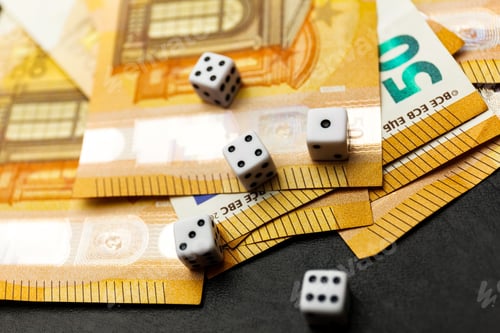 Preview: White Gaming dice and money on dark table.