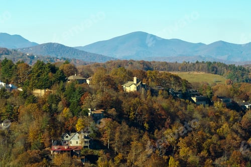 Preview: Aerial view of big family houses on mountain top between yellow trees in North Carolina