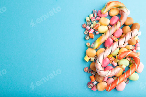 Preview: Various caramel candies on blue background. copy space, top view