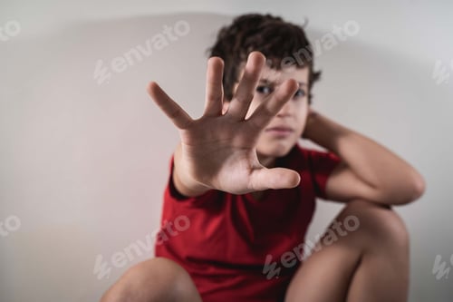 Preview: Kid hiding face with his hand asking to stop violence. No violence against children concept.
